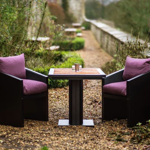 Industrial Table with Steel Framing and a Rust Style Top Ironfire Bistro Table with rust top and purple cushioned chairs